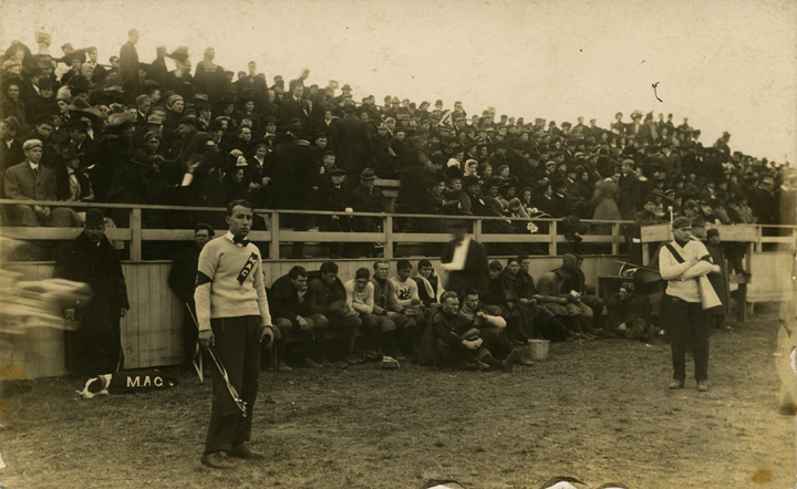 Fans, players, and cheerleaders on the sidelines at a M.A.C. football game