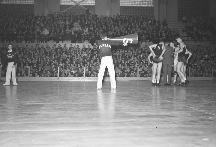 Male cheerleader on court during time out of basketball game