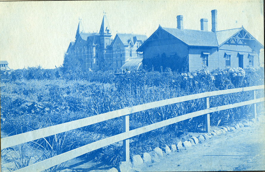 03. Campus view of a field, greenhouse and Wells Hall (I), circa 1888.