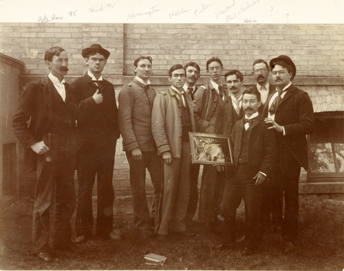 A group of students poses with a frame, 1895