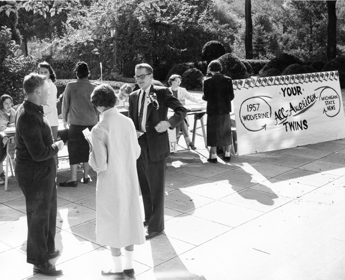 Wolverine [yearbook] Staff members speak with students, 1957