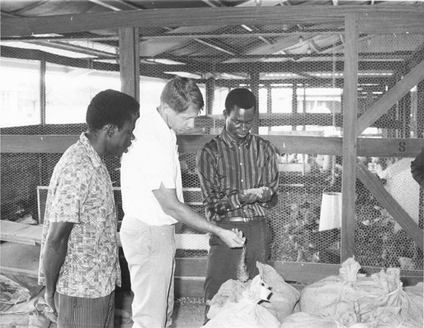 Men in the Nigeria Project examine a chicken coop, date unknown