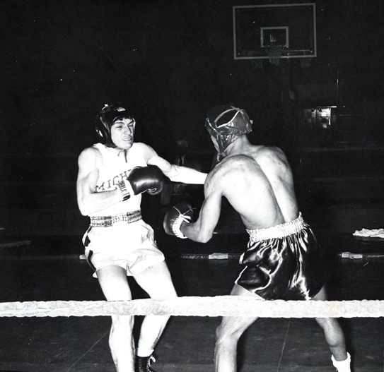 Two men boxing in the ring, 1957