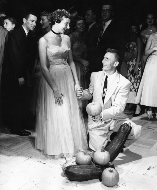 A couple poses with produce at the Harvest Dance, 1955