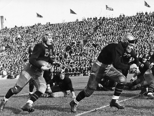 Football players mid-game, ca. 1940s