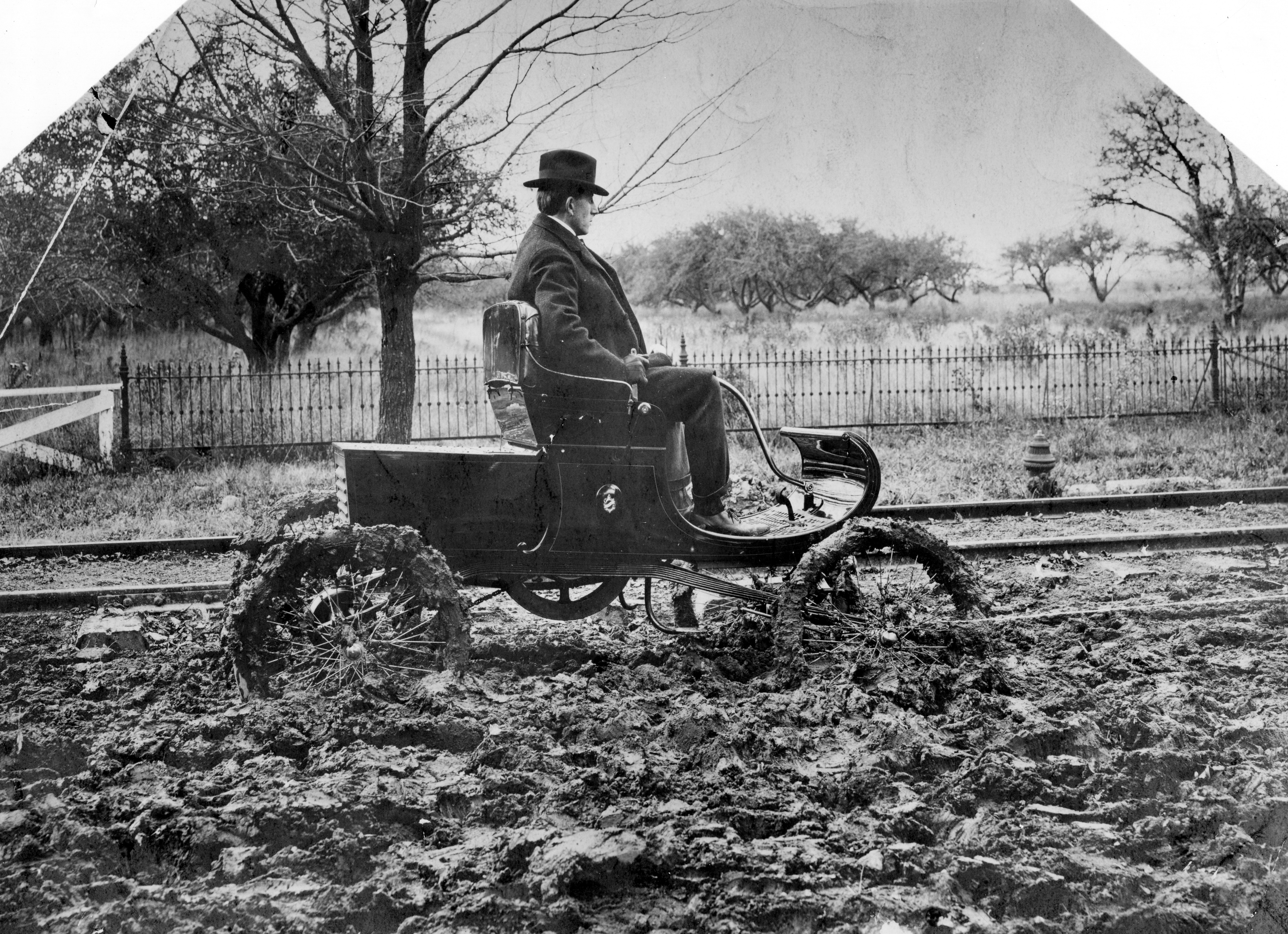 Ransom Olds drives a car in the mud