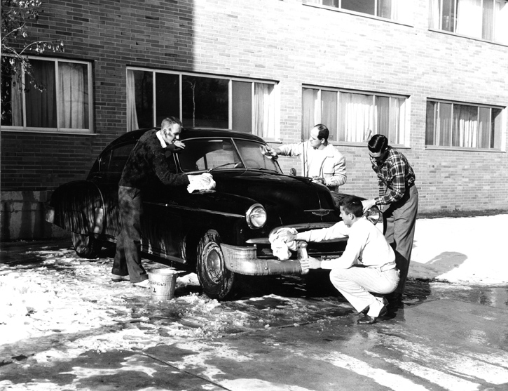 Students wash a car outside of Butterfield Hall in 1958
