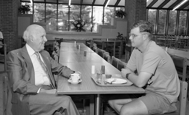 Gordon Guyer eating breakfast with students, 1992