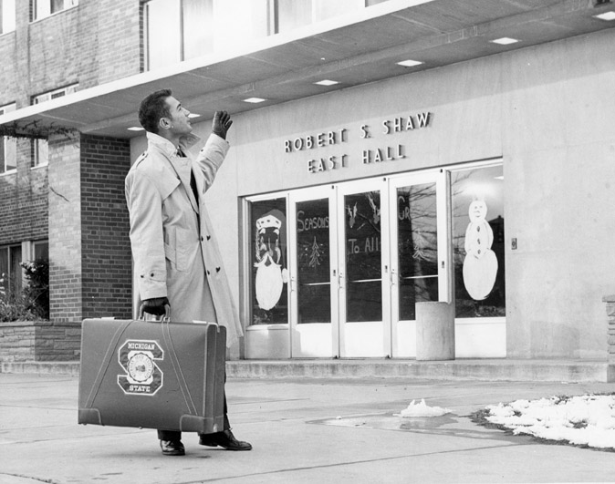 Man standing outside Shaw Hall, undated