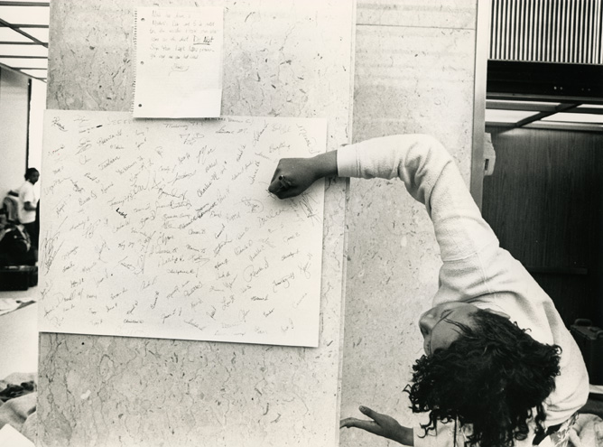 A female student signs a card during the 1989 Hannah Building student occupation.