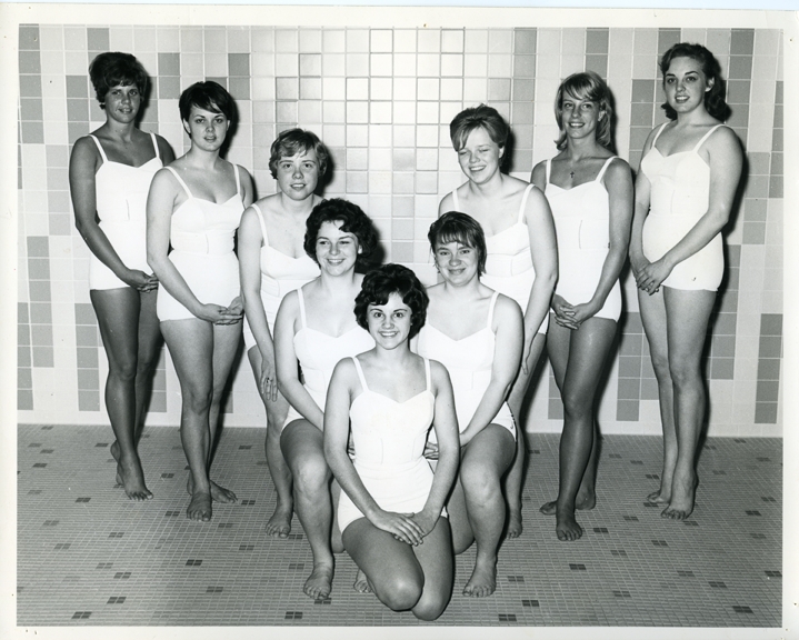 9 women posing in a V formation