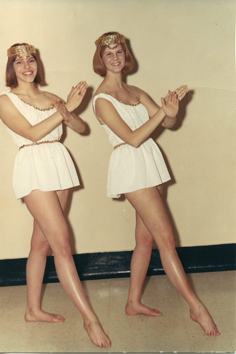 Two women in white tunics posing